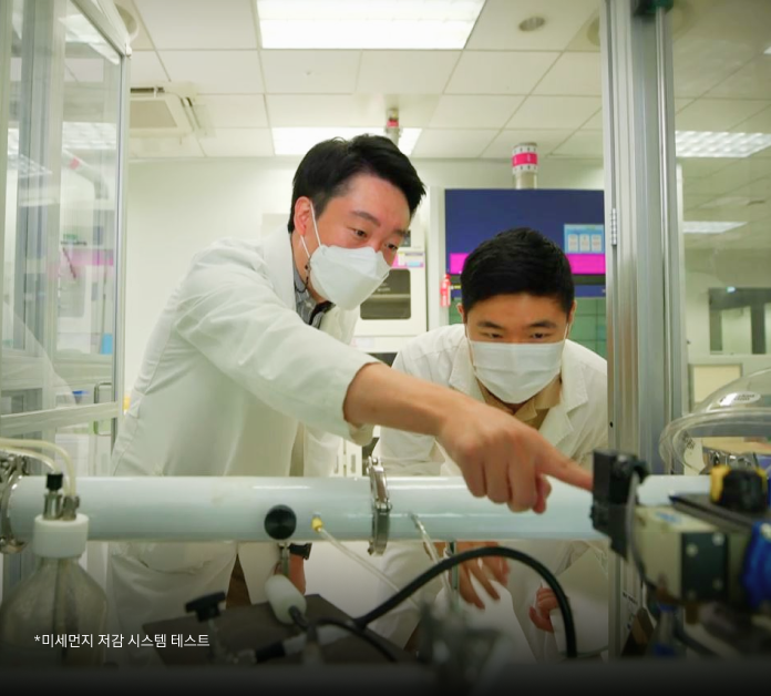 두 명의 연구원이 미세먼지 저감 시스템을 관찰하는 모습